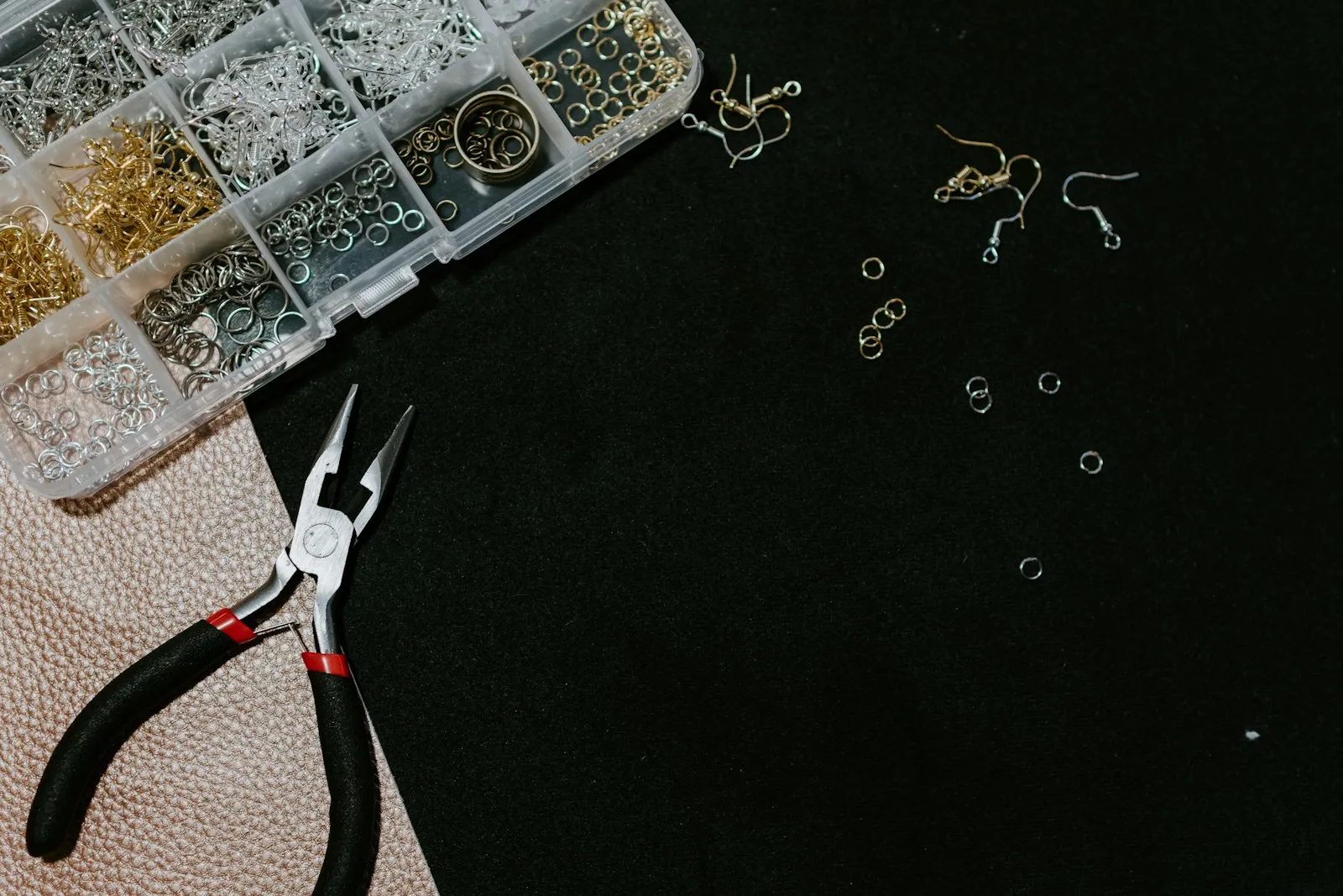 A permanent-jewelry artist's booth at a weekend market, chain and tools laid out on a linen-covered table